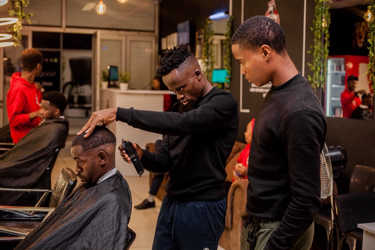 Barbers at work in a busy Joe's Fade Cuts